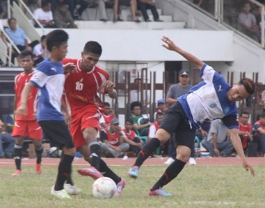 Pemain Merangin Rido (tengah dengan kostum merah) tengah merebut bola dengan dua pemain Tanjab Timur